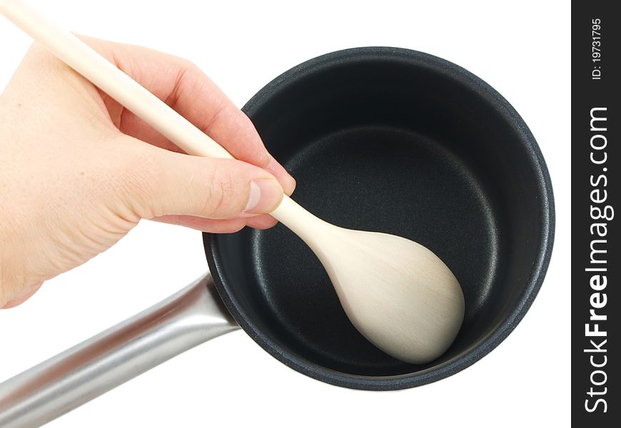 Stainless steel kettle, with wooden spatula and human hand, isolated towards white background