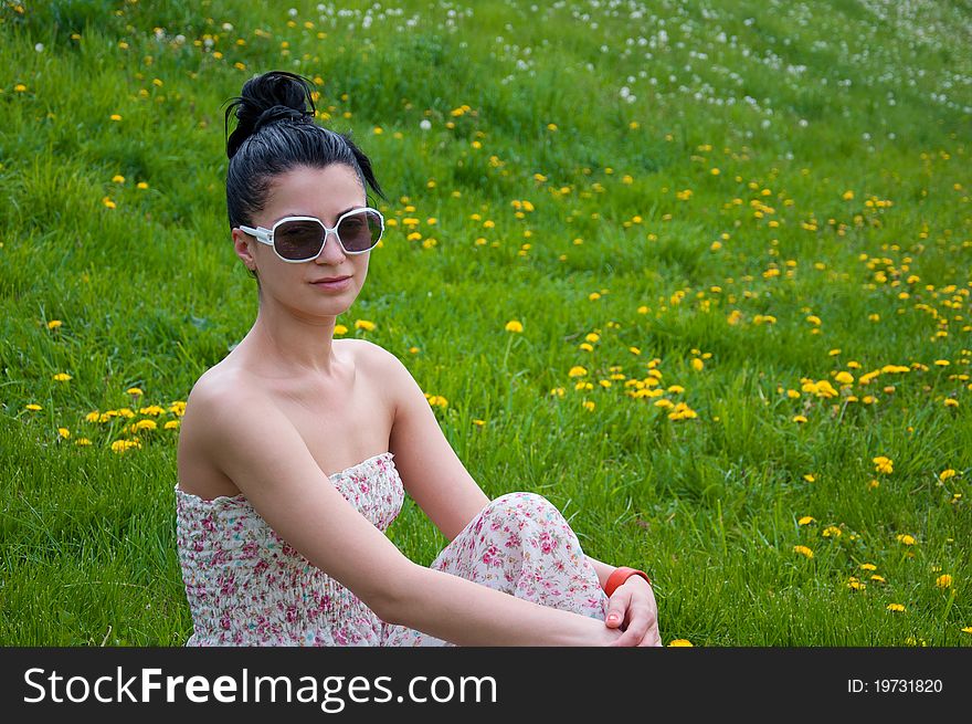 A young beautiful girl rests in a park. A young beautiful girl rests in a park