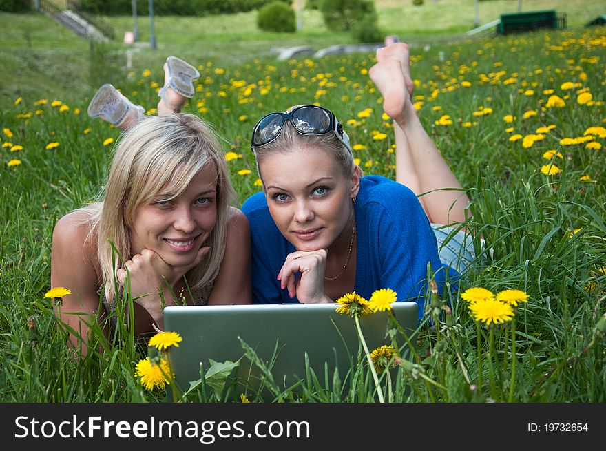 Two girls student with a laptop in the park