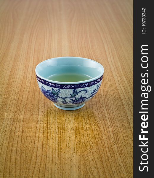 Small cup of tea in Chinese's style on wooden table. Small cup of tea in Chinese's style on wooden table