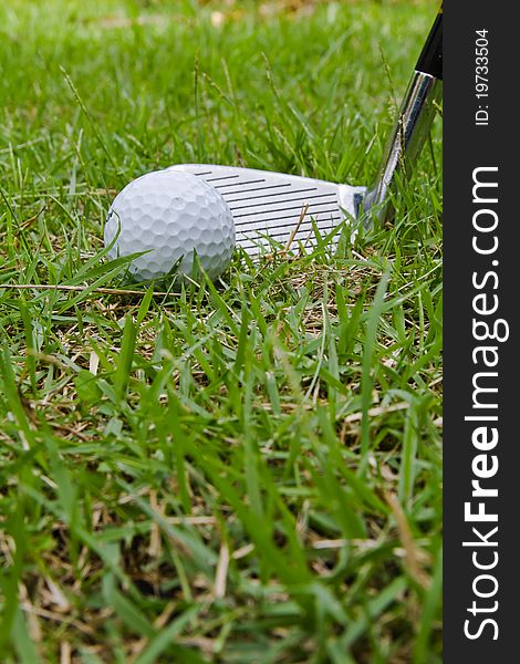 Golf ball and wedge in rough grass situation. Golf ball and wedge in rough grass situation