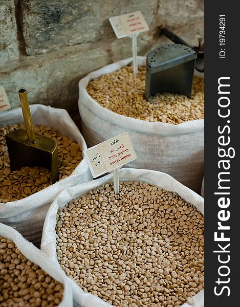 Sacks of dry beans with various metal scoops line the walls of a market in Nazareth, Israel. Sacks of dry beans with various metal scoops line the walls of a market in Nazareth, Israel.
