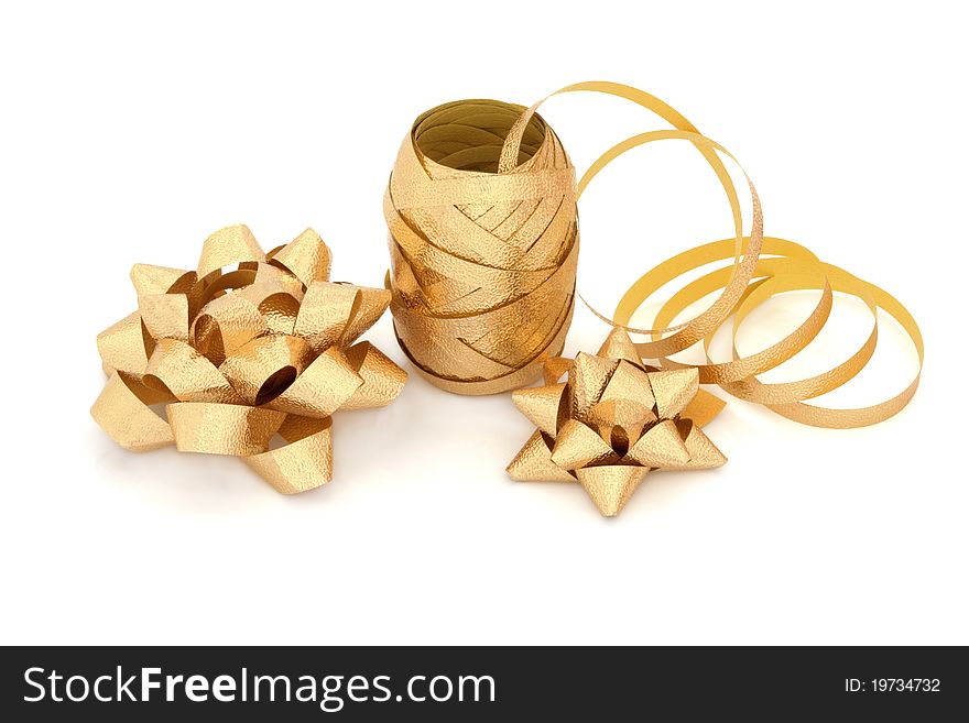 Gold ribbon on a roll and gift bow decorations isolated over white background. Gold ribbon on a roll and gift bow decorations isolated over white background.