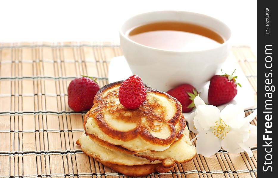 Pancakes with strawberry and cup of tea