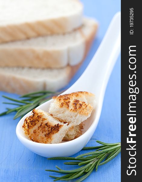 Fresh croutons on spoon and rosemary