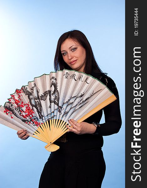 Portrait of a beautiful woman with fantail on blue background