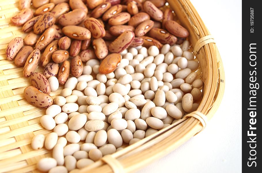 Pods of red and white beans on white background