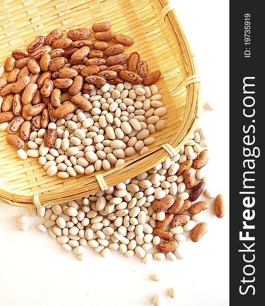 Pods of red and white beans on white background