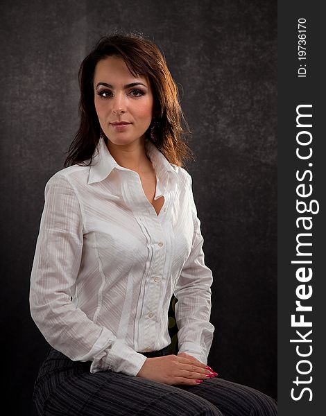 Portrait of an attractive woman in a white blouse on a black background