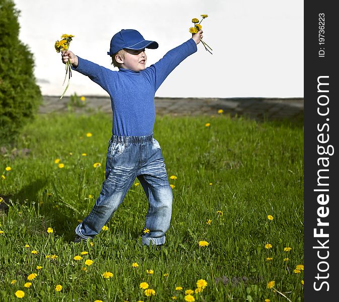 Happy boy with dandelions playing