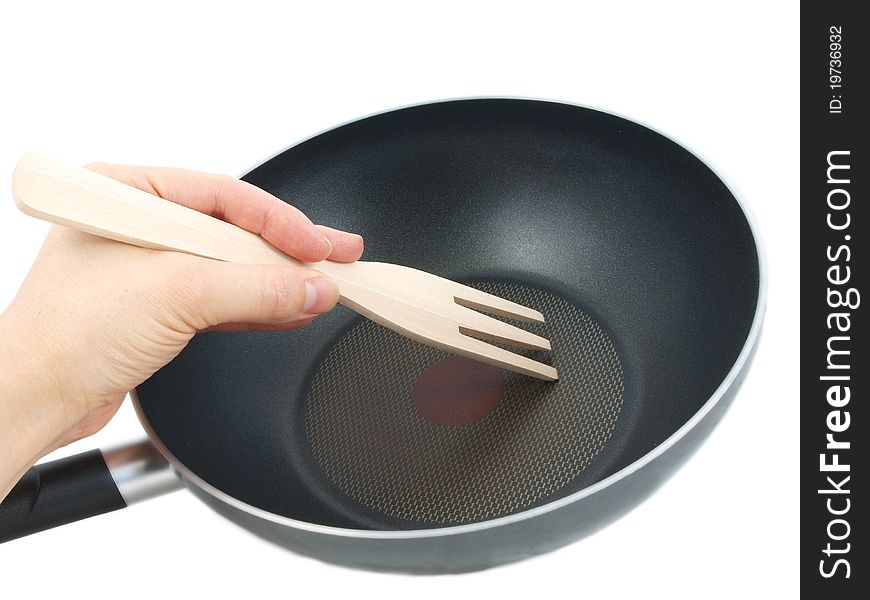 Frying pan with wooden spatula, isolated with human hand towards white background