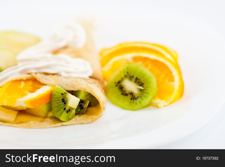 Pancakes with kiwi, orange, apple and creme isolated on white background. Pancakes with kiwi, orange, apple and creme isolated on white background