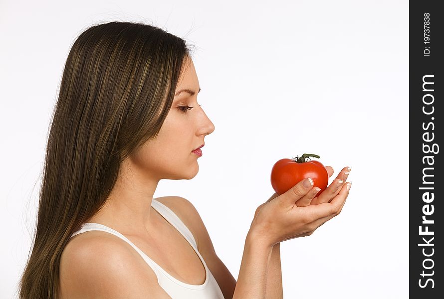 Young woman looking at a fresh tomato