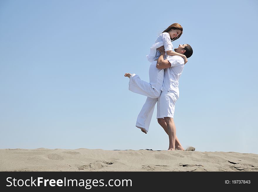 Happy young couple have fun and romantic moments on beach at summer season and representing happynes and travel concept. Happy young couple have fun and romantic moments on beach at summer season and representing happynes and travel concept