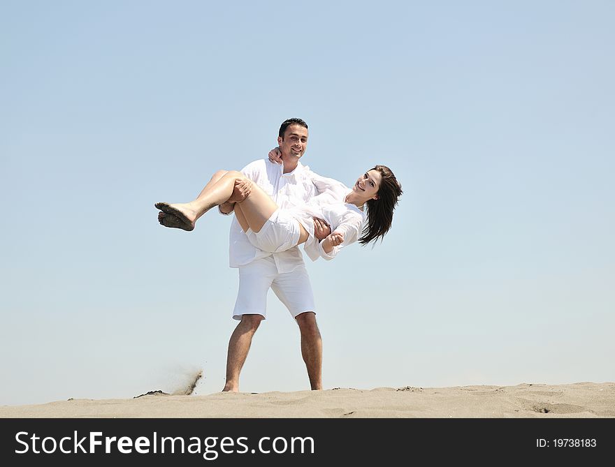 Happy young couple have fun and romantic moments on beach at summer season and representing happynes and travel concept. Happy young couple have fun and romantic moments on beach at summer season and representing happynes and travel concept