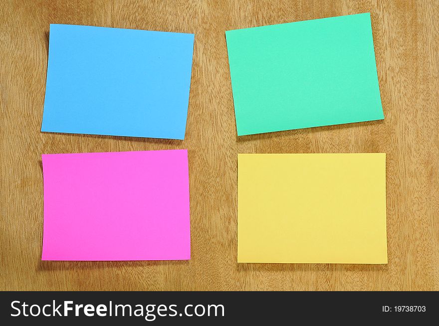 Colorful blank memo note on plywood board background. Colorful blank memo note on plywood board background