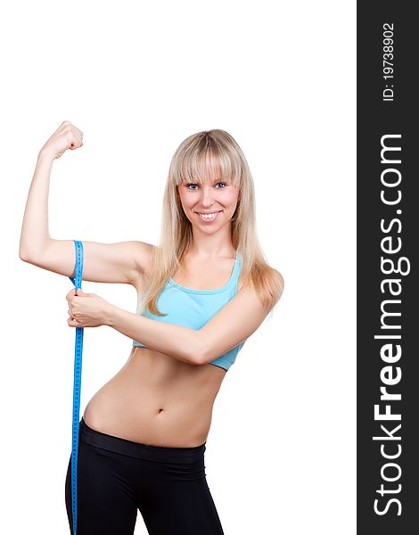 Young and blond woman smile, measuring her arm muscle by measure tape, isolated over white background. Young and blond woman smile, measuring her arm muscle by measure tape, isolated over white background