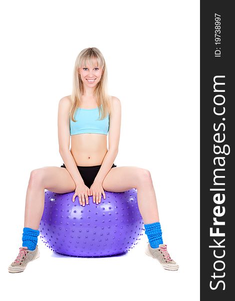 Young woman doing fitness exercise with a violet ball, smile. isolated over white background. Young woman doing fitness exercise with a violet ball, smile. isolated over white background.