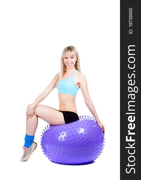 Young woman doing fitness exercise with a violet ball, smile. isolated over white background. Young woman doing fitness exercise with a violet ball, smile. isolated over white background.