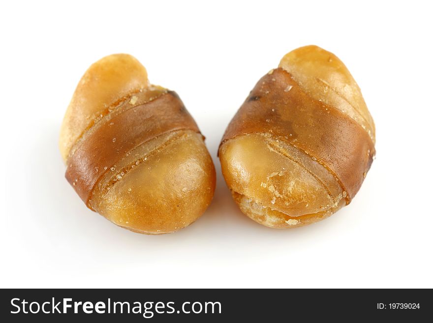 Close up of two seasoned horse beans isolated on white background.