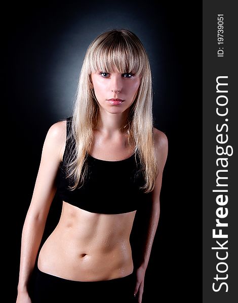 Young attractive, beautiful fitness woman standing over black background. Fitness sport Concept.