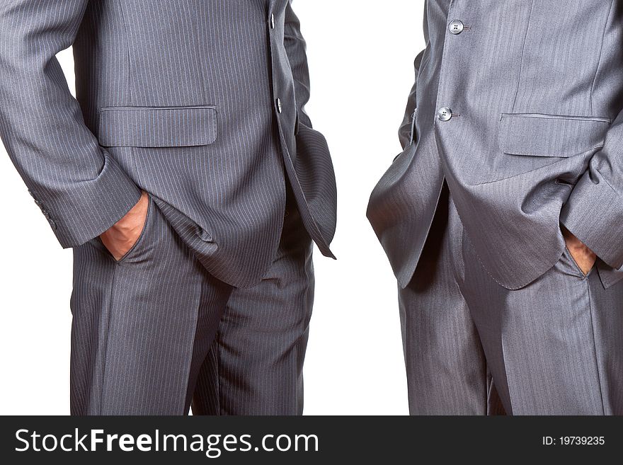 Professionally well dressed two caucasian businessmen in elegant suits, top managers standing holding hands in pockets isolated on white background. Concept corporate. Professionally well dressed two caucasian businessmen in elegant suits, top managers standing holding hands in pockets isolated on white background. Concept corporate.