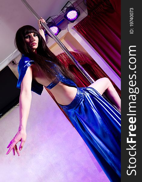 Young attractive woman in silk costume dances strip tease in the adult entertainment club. Young attractive woman in silk costume dances strip tease in the adult entertainment club