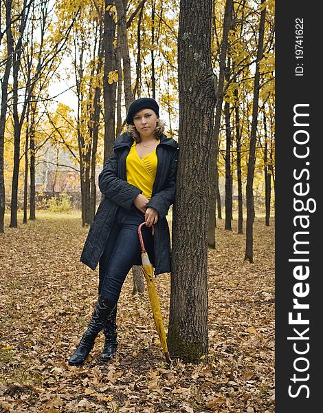 Pretty woman with yellow umbrella standing in autumn park. Pretty woman with yellow umbrella standing in autumn park