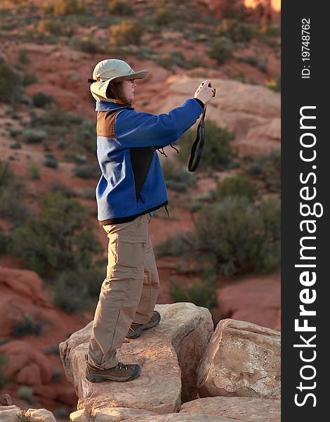 Woman photographer captures the sunset in Arches National Park. Woman photographer captures the sunset in Arches National Park