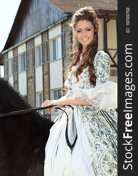 Beautiful young woman in medieval dress with a horse outdoor. Beautiful young woman in medieval dress with a horse outdoor.