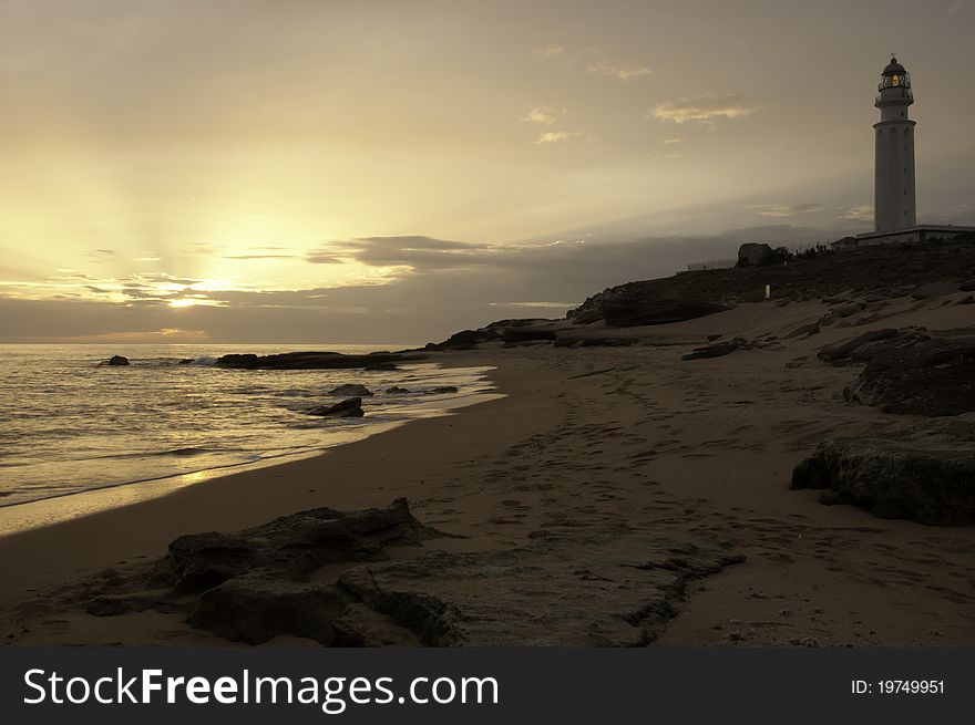 Sunset on a beach in Spain with a lighthouse. Sunset on a beach in Spain with a lighthouse