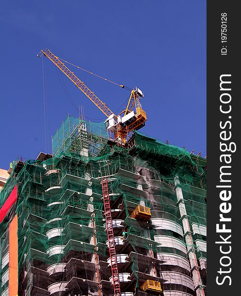 A tower condominium under construction using modern technologies and modern equipments like the one shown, the tower crane.