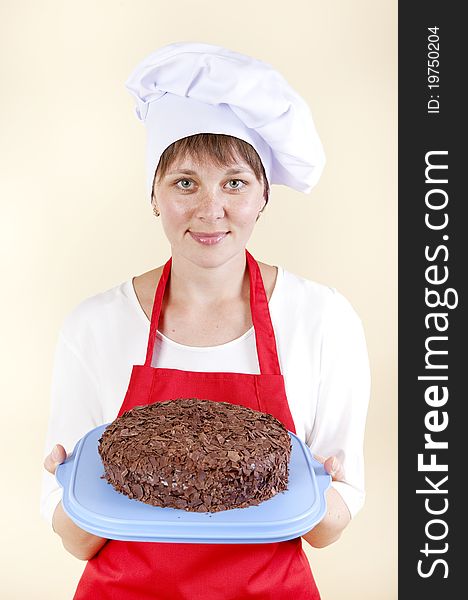 Girl chef with a cake in a red apron