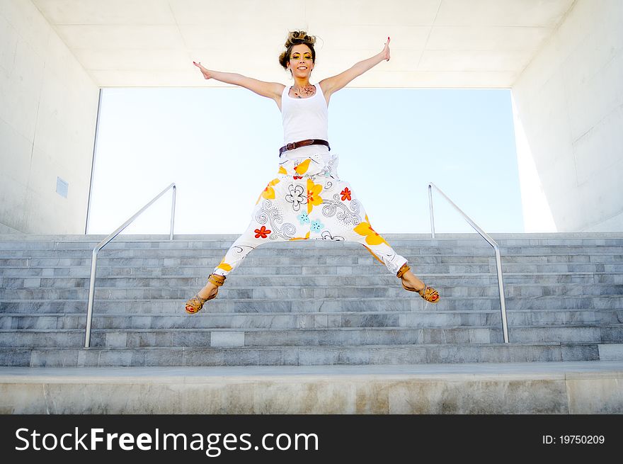 A pretty girl dressed in a fun, jumping stairs. A pretty girl dressed in a fun, jumping stairs