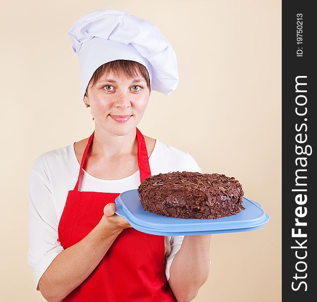 Girl chef with a cake in a red apron