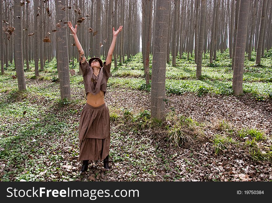 A girl by blowing the leaves of the trees in the forest. Symbol of Freedom. A girl by blowing the leaves of the trees in the forest. Symbol of Freedom
