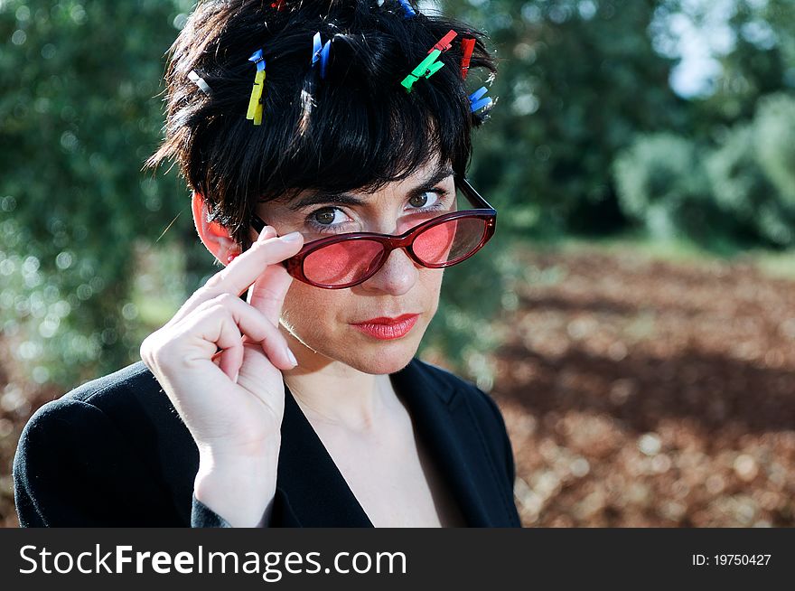 Funny picture of a girl with her hair adorned with clothespins, wearing cheerful sunglasses subject with her hands. Funny picture of a girl with her hair adorned with clothespins, wearing cheerful sunglasses subject with her hands.