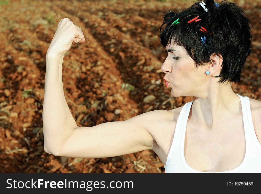 Ironic and funny picture of a woman, doing a strength gesture. Ironic and funny picture of a woman, doing a strength gesture
