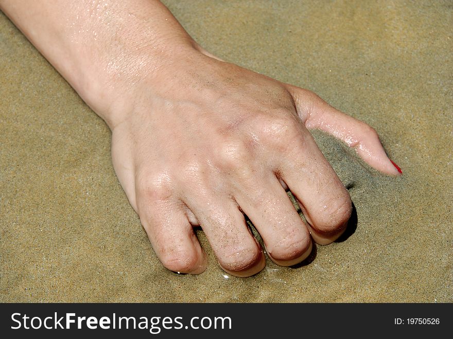 Female hand grabbing sand closeup on seaside outdoors