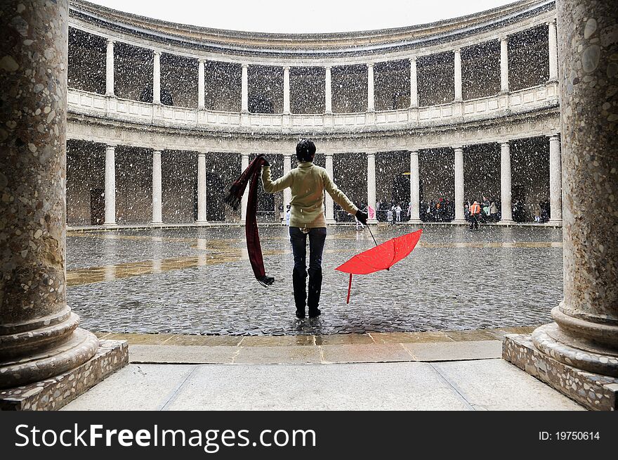 Snowing over woman with red umbrella in palace. Snowing over woman with red umbrella in palace