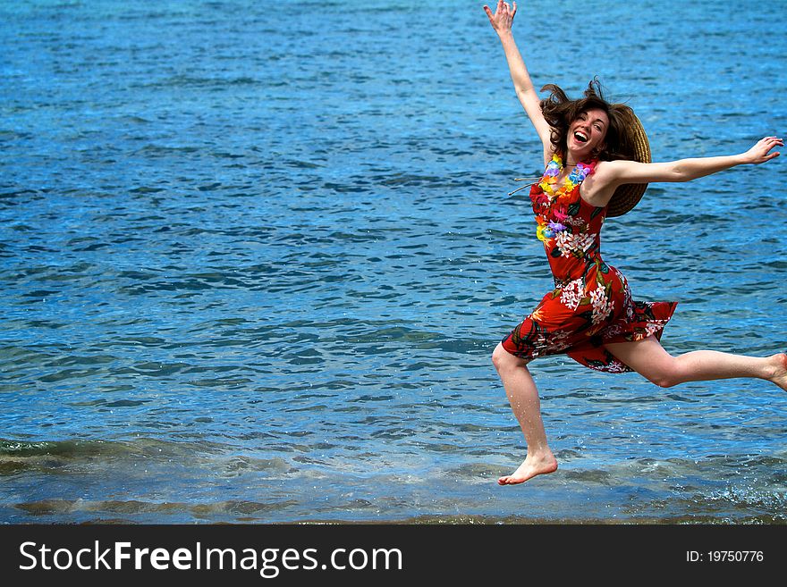 A woman jumps along the shoreline of a Maui beach, happy and excited to be on vacation in Hawaii. A woman jumps along the shoreline of a Maui beach, happy and excited to be on vacation in Hawaii.