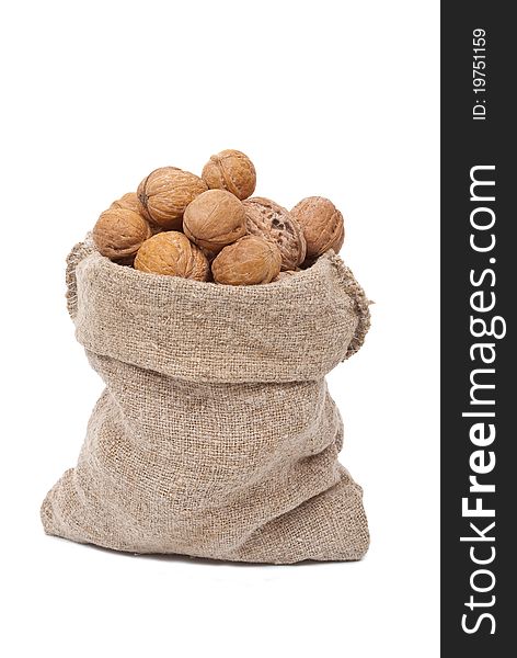 Burlap sack with walnuts on white