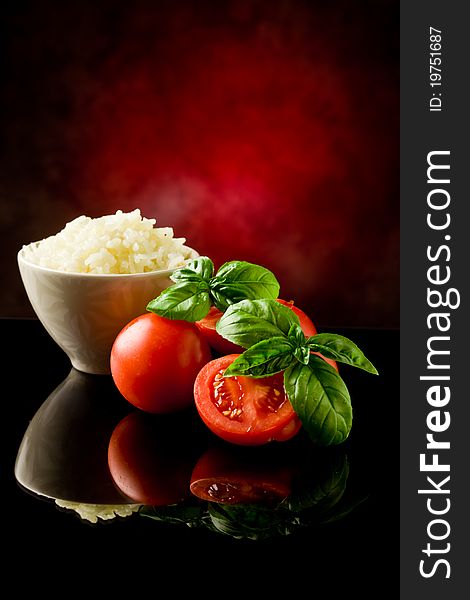 Photo of rice inside a bowl with basil and fresh cherry tomatoes. Photo of rice inside a bowl with basil and fresh cherry tomatoes