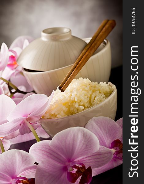 Photo of delicious asian rice dish with orchid flowers around