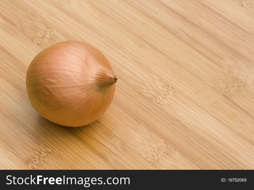 Whole brown onion on wooden table