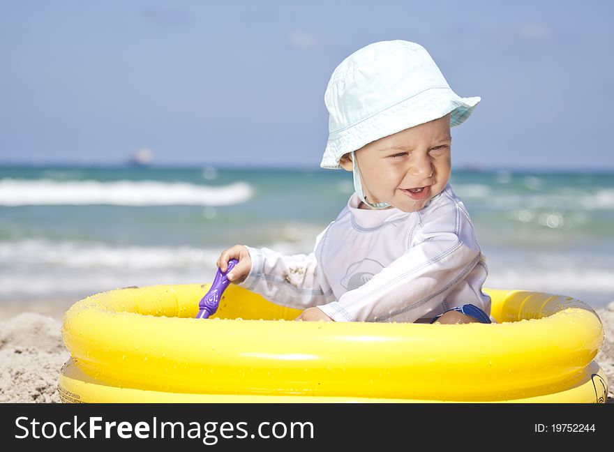 Baby playing with toys in pool on a beach. Baby playing with toys in pool on a beach