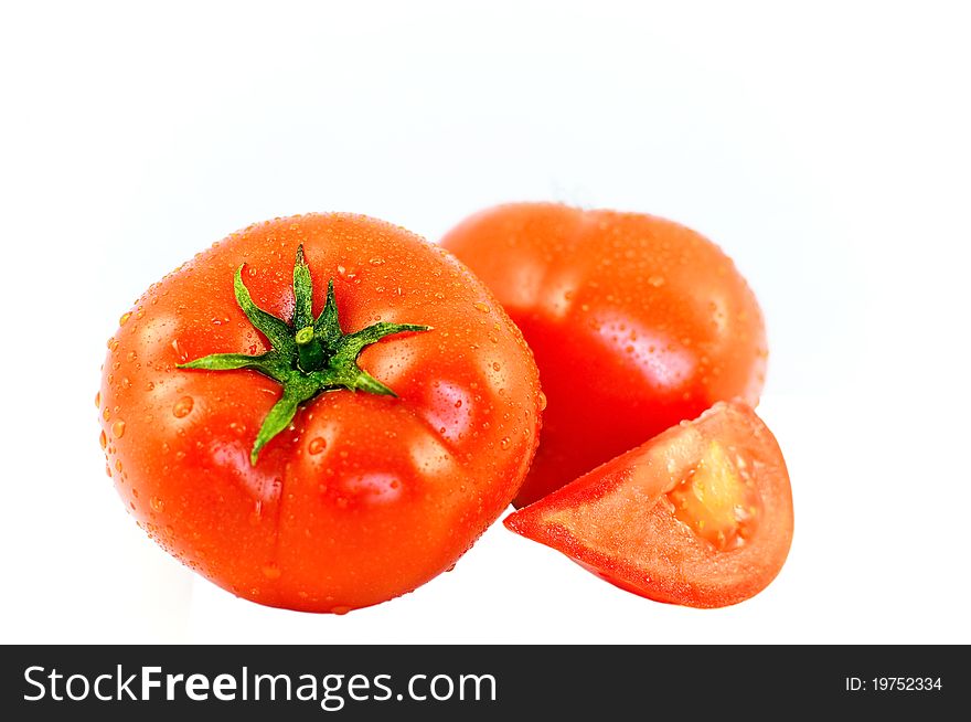 The Juicy ripe tomatoes in drop of water on white background.