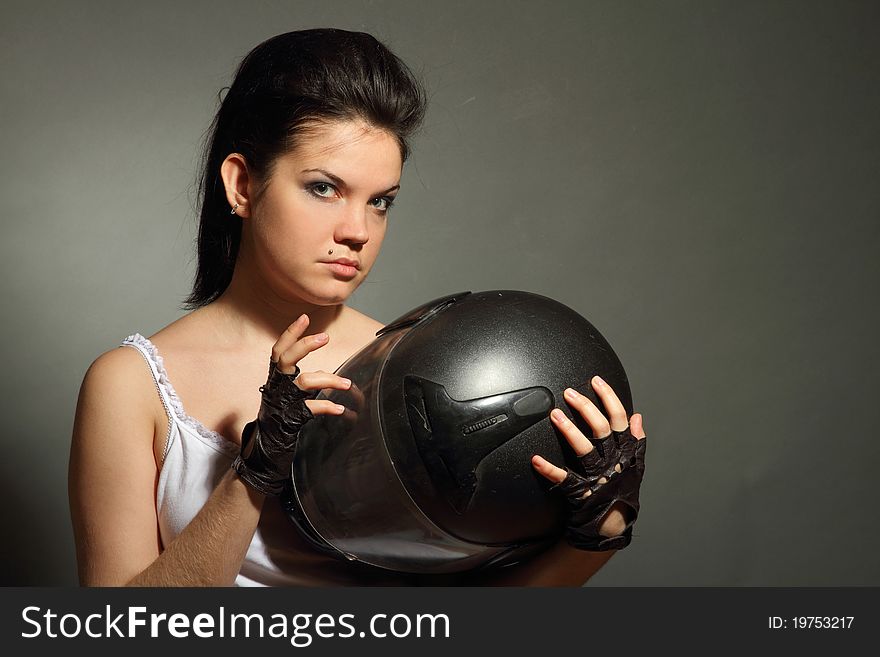 The girl with a motorcycle helmet on a gray background