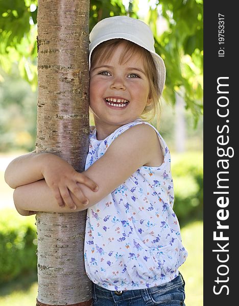 Little adorable girl posing by tree in the park. Little adorable girl posing by tree in the park