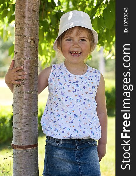 Little adorable girl posing by tree in the park. Little adorable girl posing by tree in the park